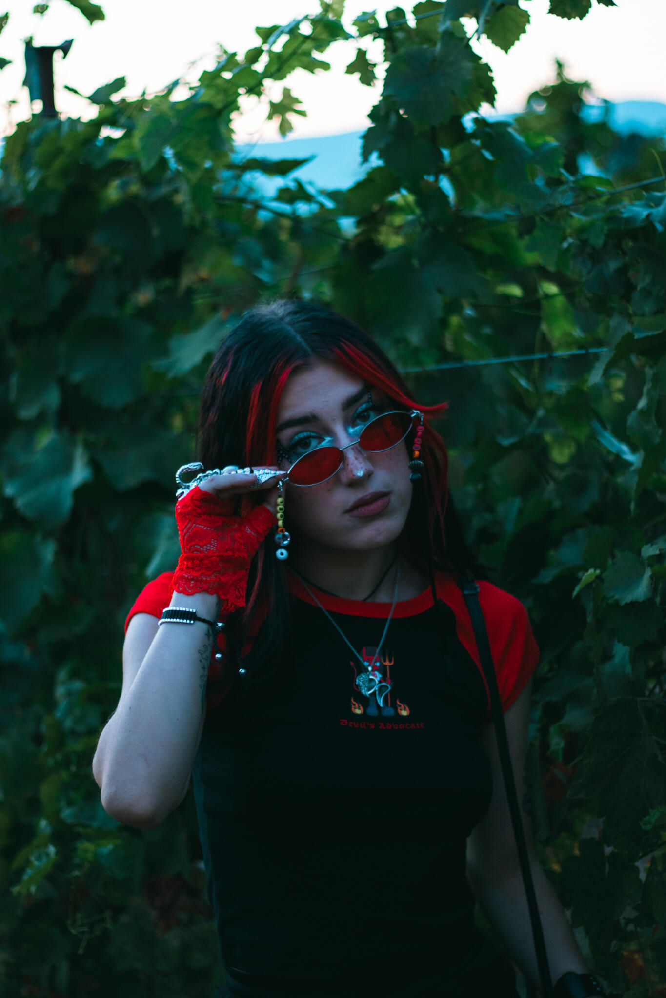The Vineyards at Frequency Sound 528 A woman with bright red hair and glasses looks directly at the viewer, emphasizing her distinctive hair color and eyewear style.