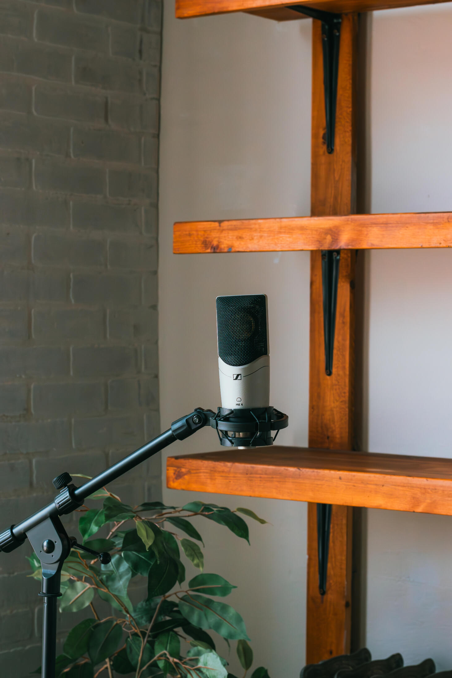 Vault 22 Multiple high-quality MIDI pianos and devices used to produce, mix, and master different music tracks, featured on a clean wood shelf with light shining on them.